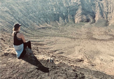 Frau blickt in Vulkankrater Caldera Blanca Lanzarote